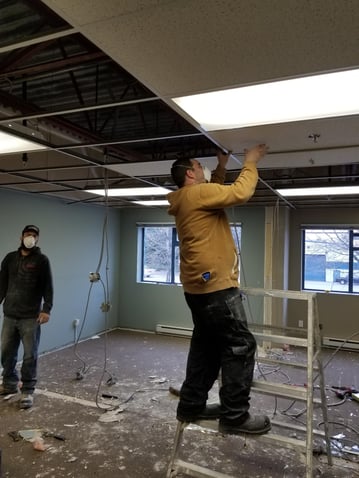 DRYSTAR crew installing a suspended ceiling inside a commercial building