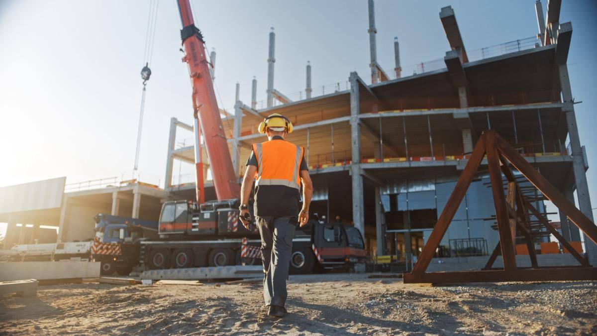 Construction worker walking on site; untracked costs concept