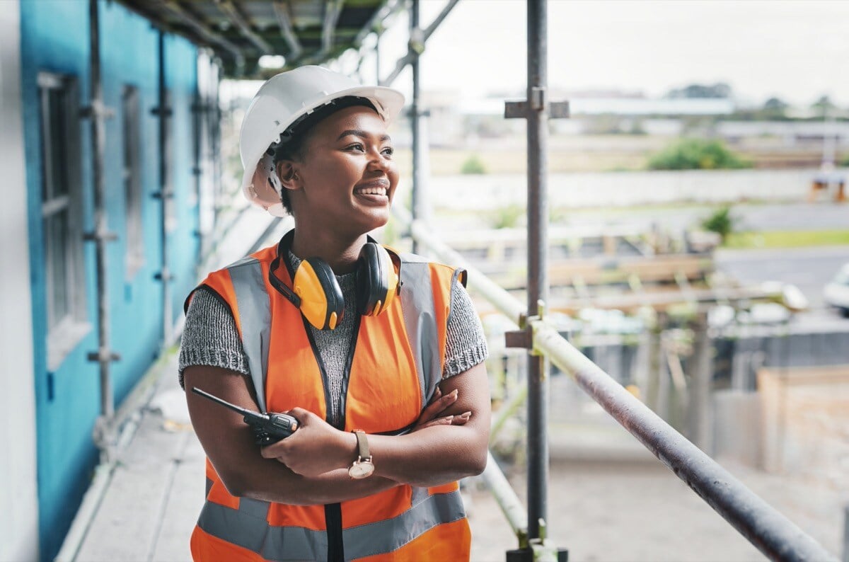 Construction industry worker standing at a building site; construction project documents concept