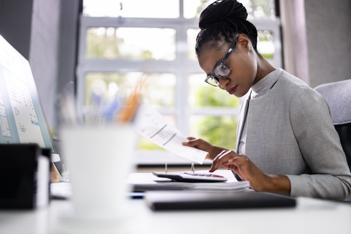 Auditor at desk with calculator; trade contractors growth planning concept