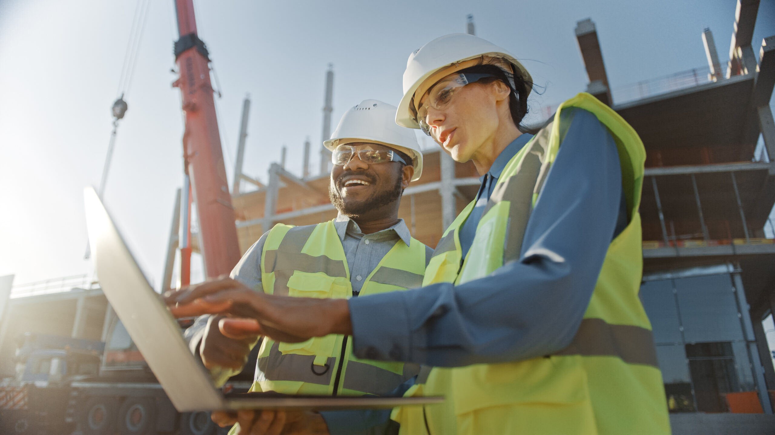 Two engineers on commercial building site, reviewing online documentation; project documentation mental toll concept