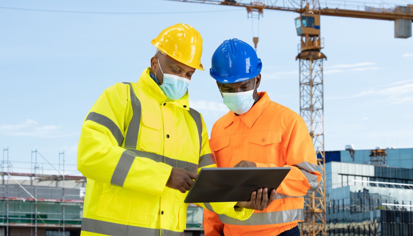 Construction engineer and building inspector looking at tablet on site; skills gap concept
