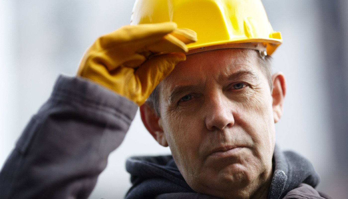 Close-up of older worker in hard hat; skills gap concept