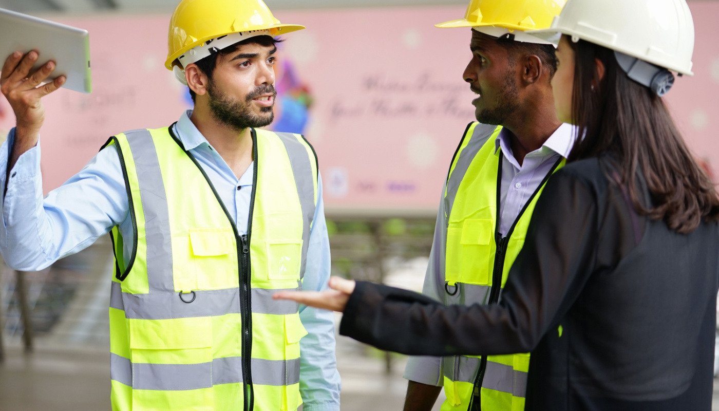 Group of construction workers talking; centralized construction project data concept