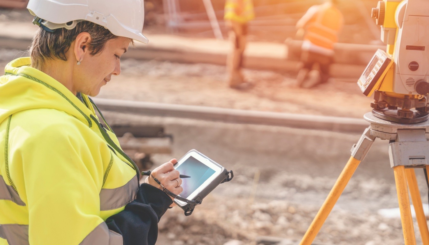 Site engineer surveyor working on electronic device; starting construction business concept