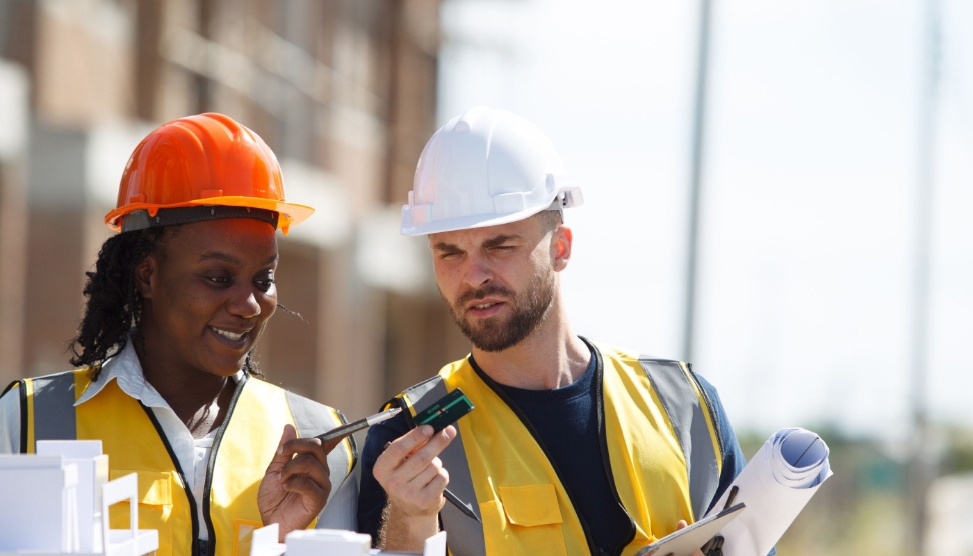 ESU175 TWO Two workers in hard hats on construction site; budget overruns concept