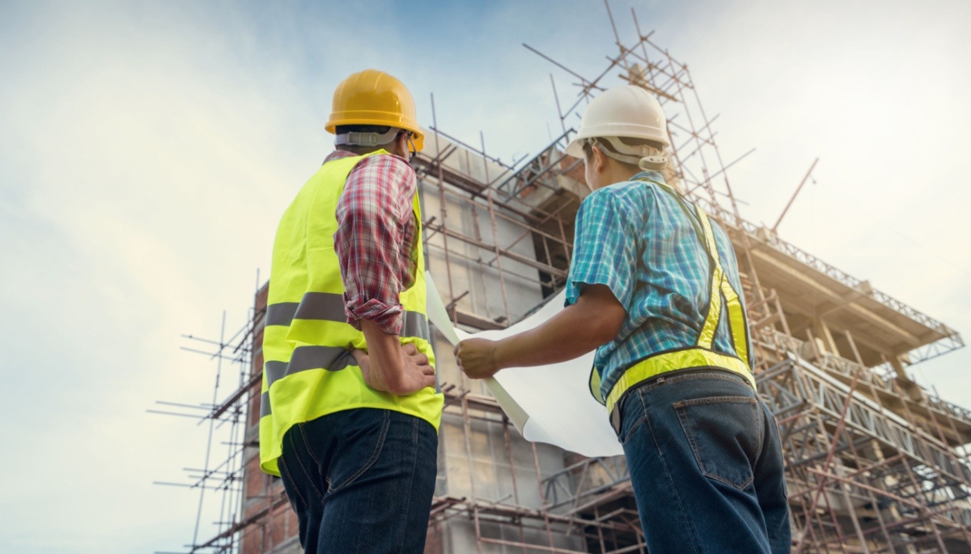 Engineer talking to worker at a construction site; reduce project risks concept