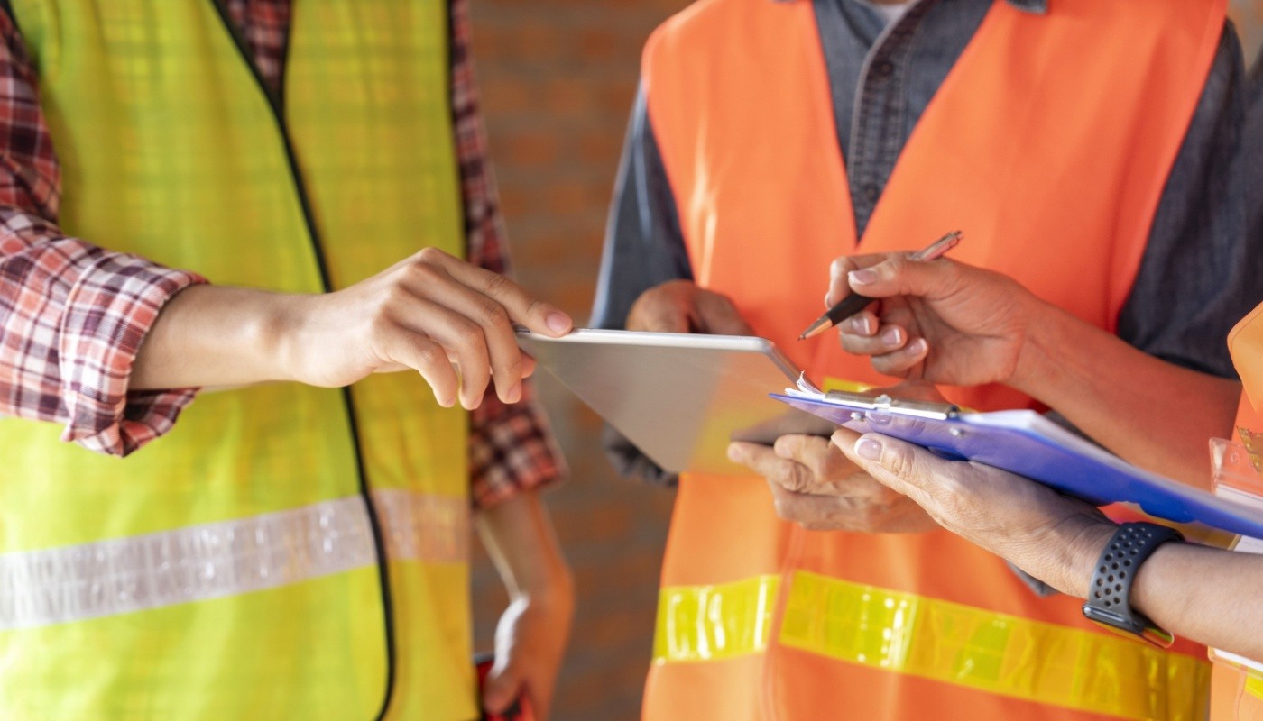 Construction workers in discussion on site; construction software flexibility