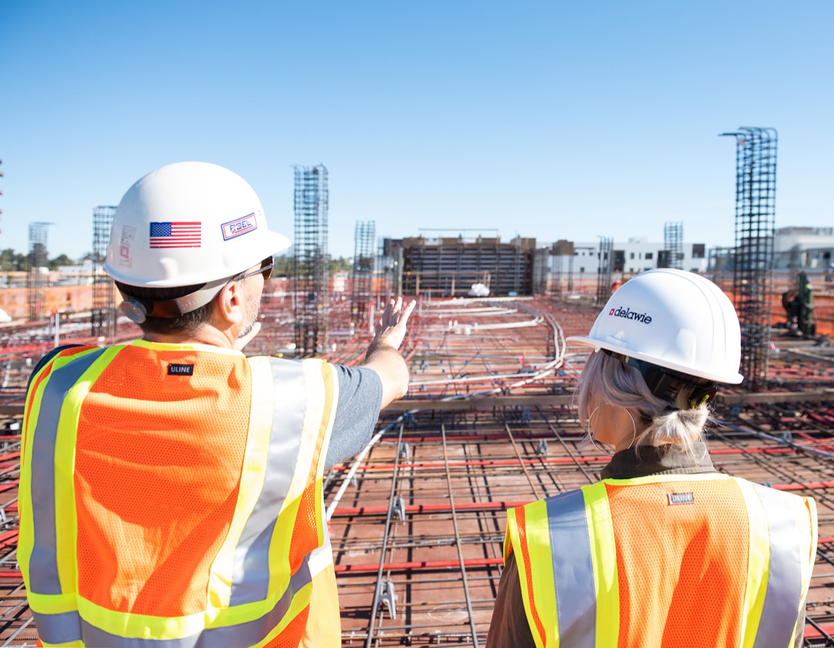 Construction workers overlooking site; track with hard data