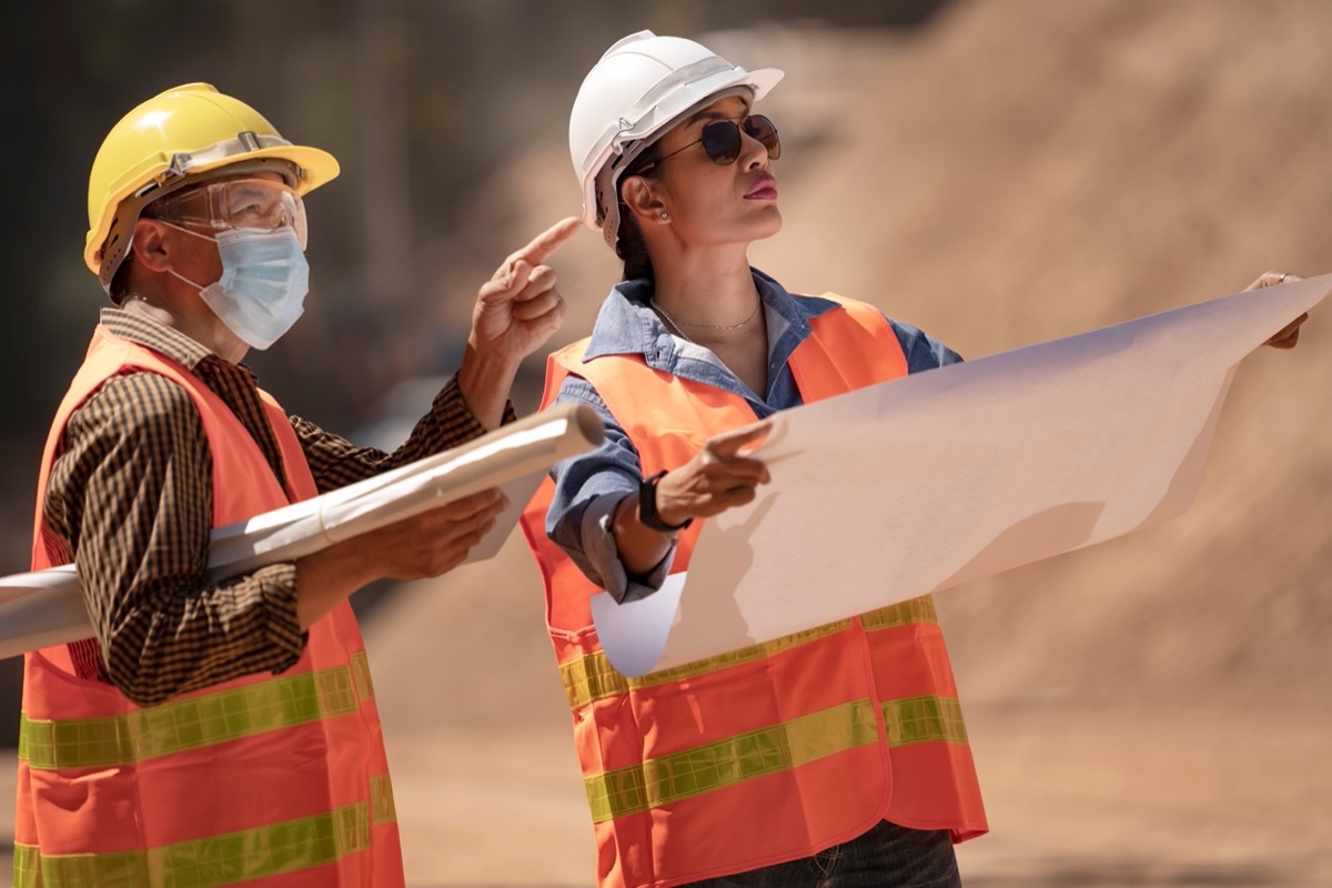 Workers looking at plans on construction site; document your job site concept