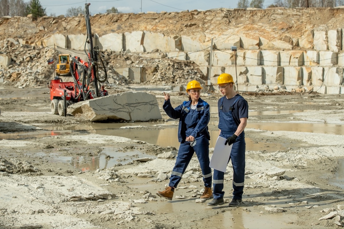 Two construction workers walking on site; worksite data concept