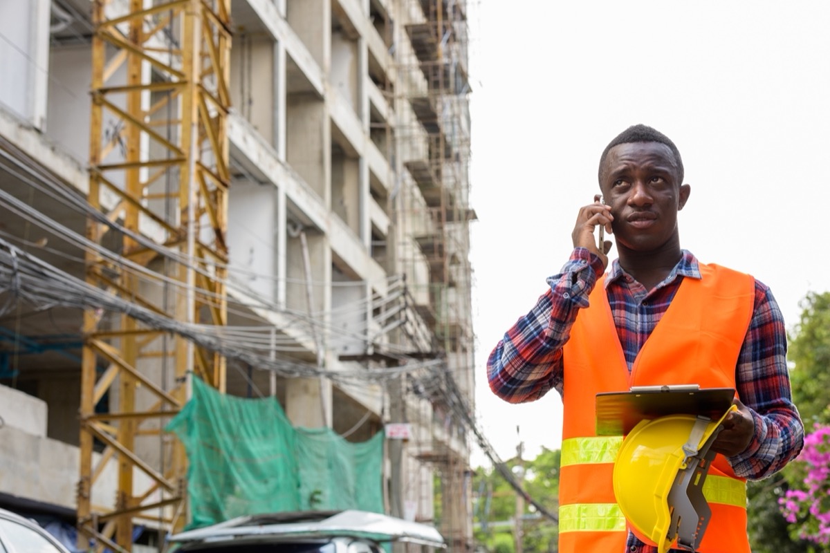 Construction worker on site using phone; document your job site concept