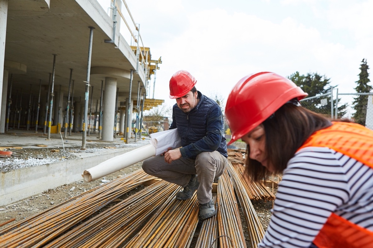 Two workers on construction site; worksite data concept