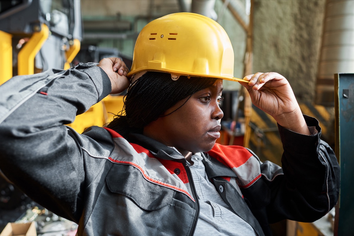 Woman in uniform putting her hardhat on; write better proposals concept