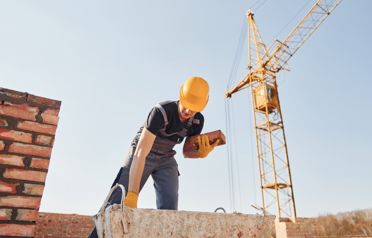 Construction worker doing bricklaying on building; supplier payment terms concept