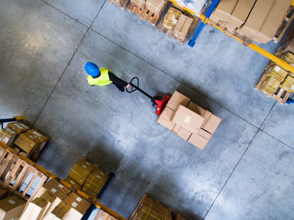Warehouse worker pulling a pallet truck; supplier payment terms concept