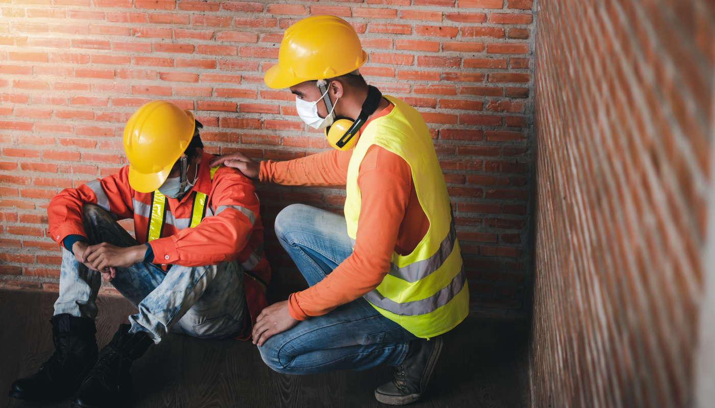 Worker comforting another, with hand on his shoulder; 