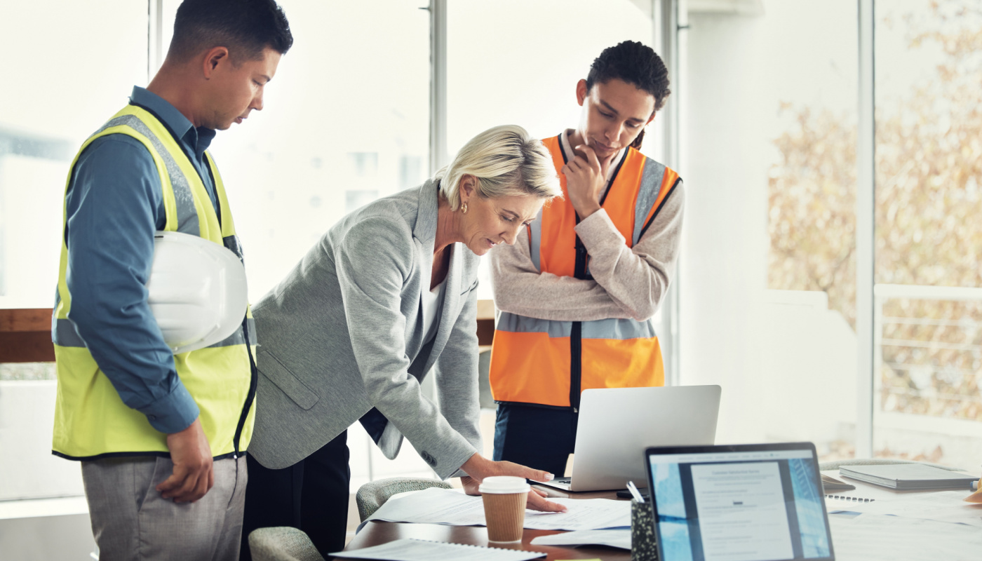 Construction workers in office with team leader; job productivity concept