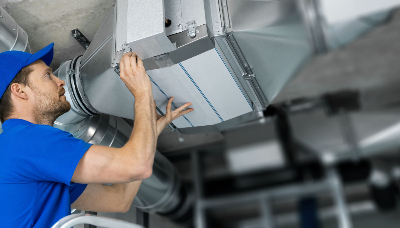 HVAC technician at work on ventilation system installation or repair; rework concept