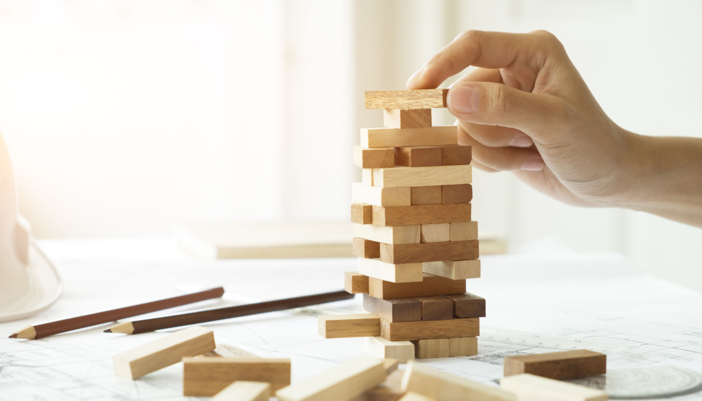 Close-up of person playing Jenga; project risk concept