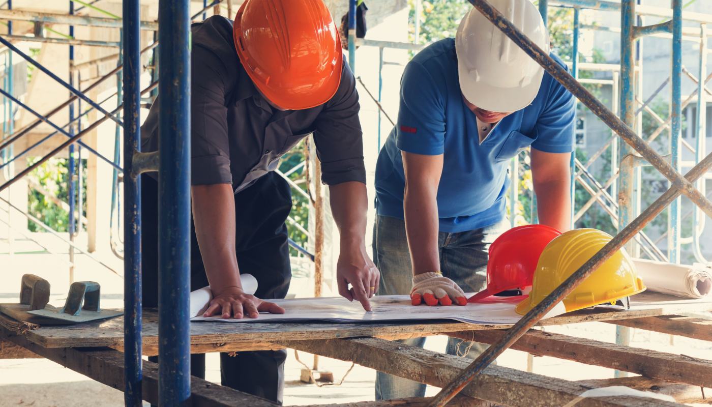 Engineer and architect in hardhats at construction site with blueprint; boost productivity concept